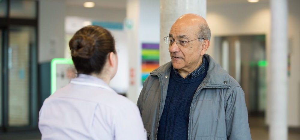 Man talking to female healthcare assistant